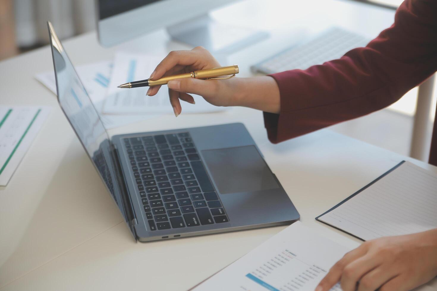 Cropped image of professional businesswoman working at her office via laptop, young female manager using portable computer device while sitting at modern loft, flare light, work process concept photo