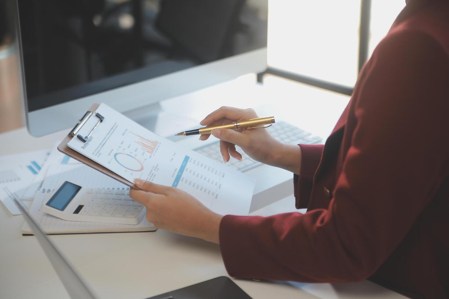 Cropped image of professional businesswoman working at her office via laptop, young female manager using portable computer device while sitting at modern loft, flare light, work process concept photo