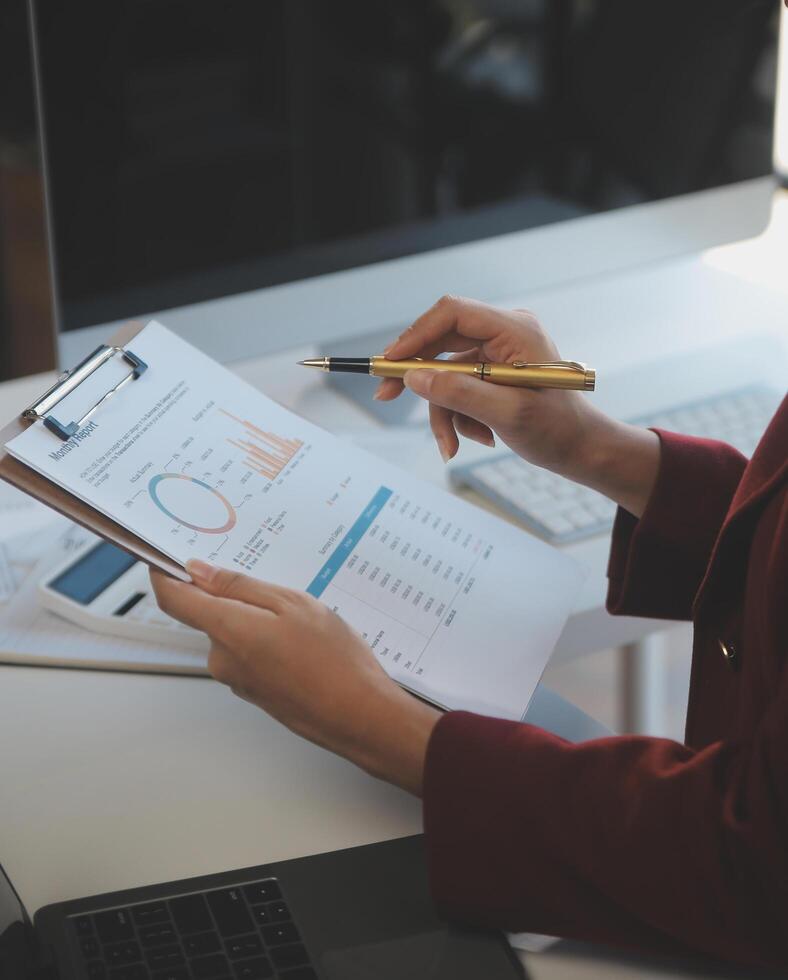 Cropped image of professional businesswoman working at her office via laptop, young female manager using portable computer device while sitting at modern loft, flare light, work process concept photo