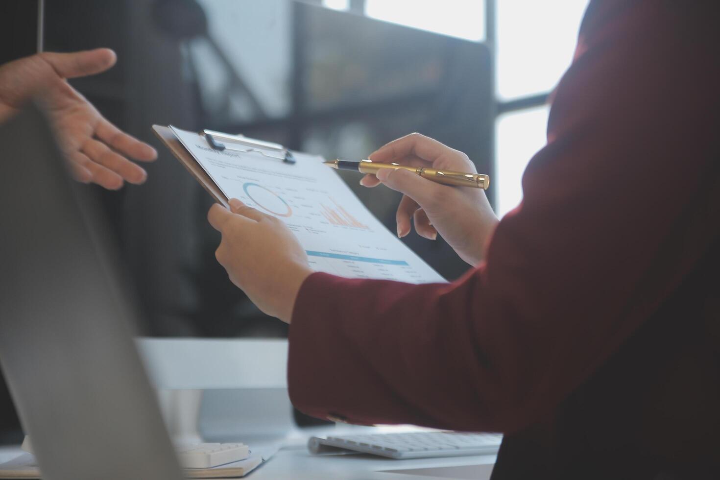 Cropped image of professional businesswoman working at her office via laptop, young female manager using portable computer device while sitting at modern loft, flare light, work process concept photo