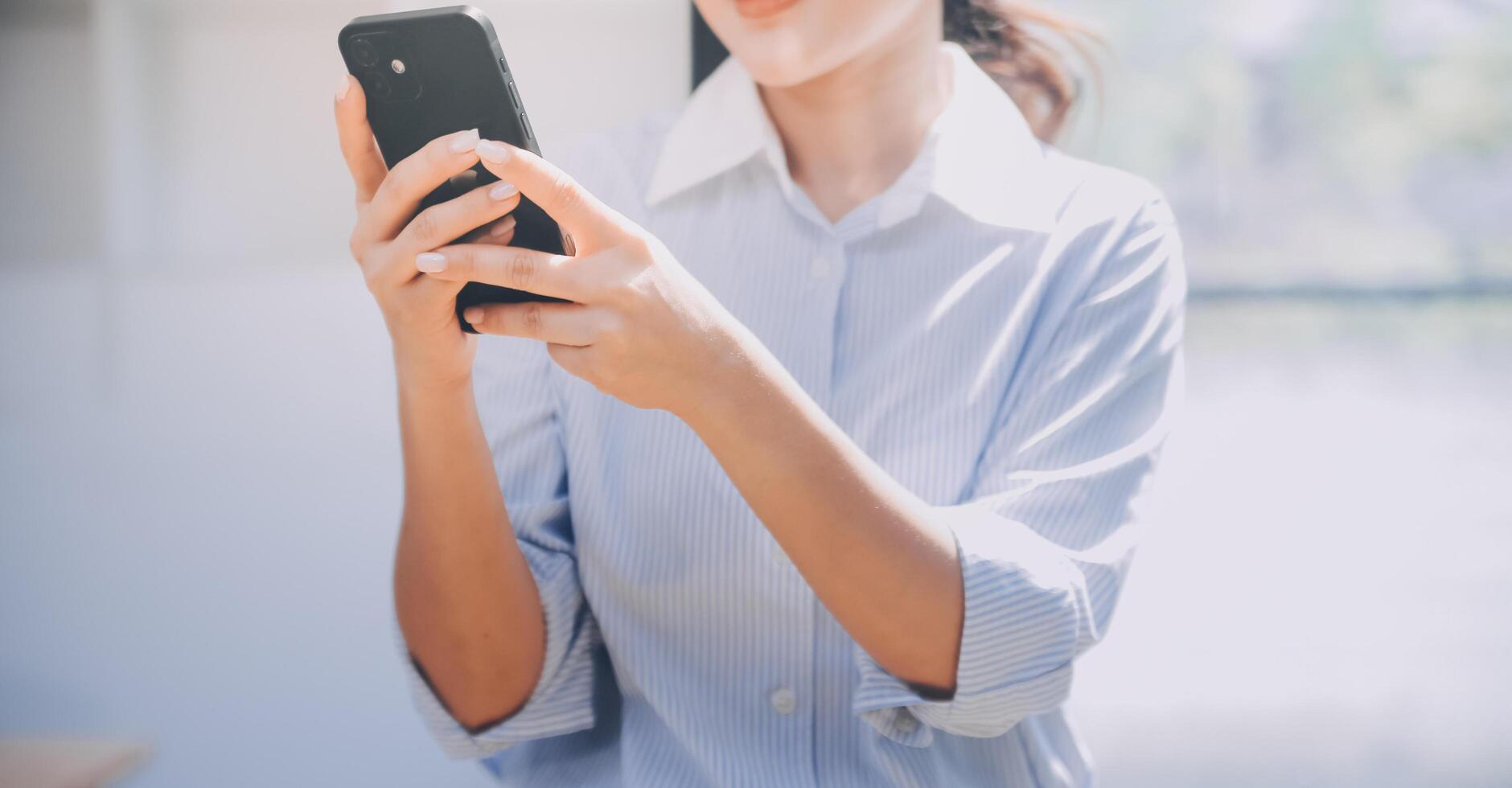 retrato de un contento asiático mujer de negocios utilizando móvil teléfono interior, asiático mujer de negocios trabajando en moderno oficina. foto