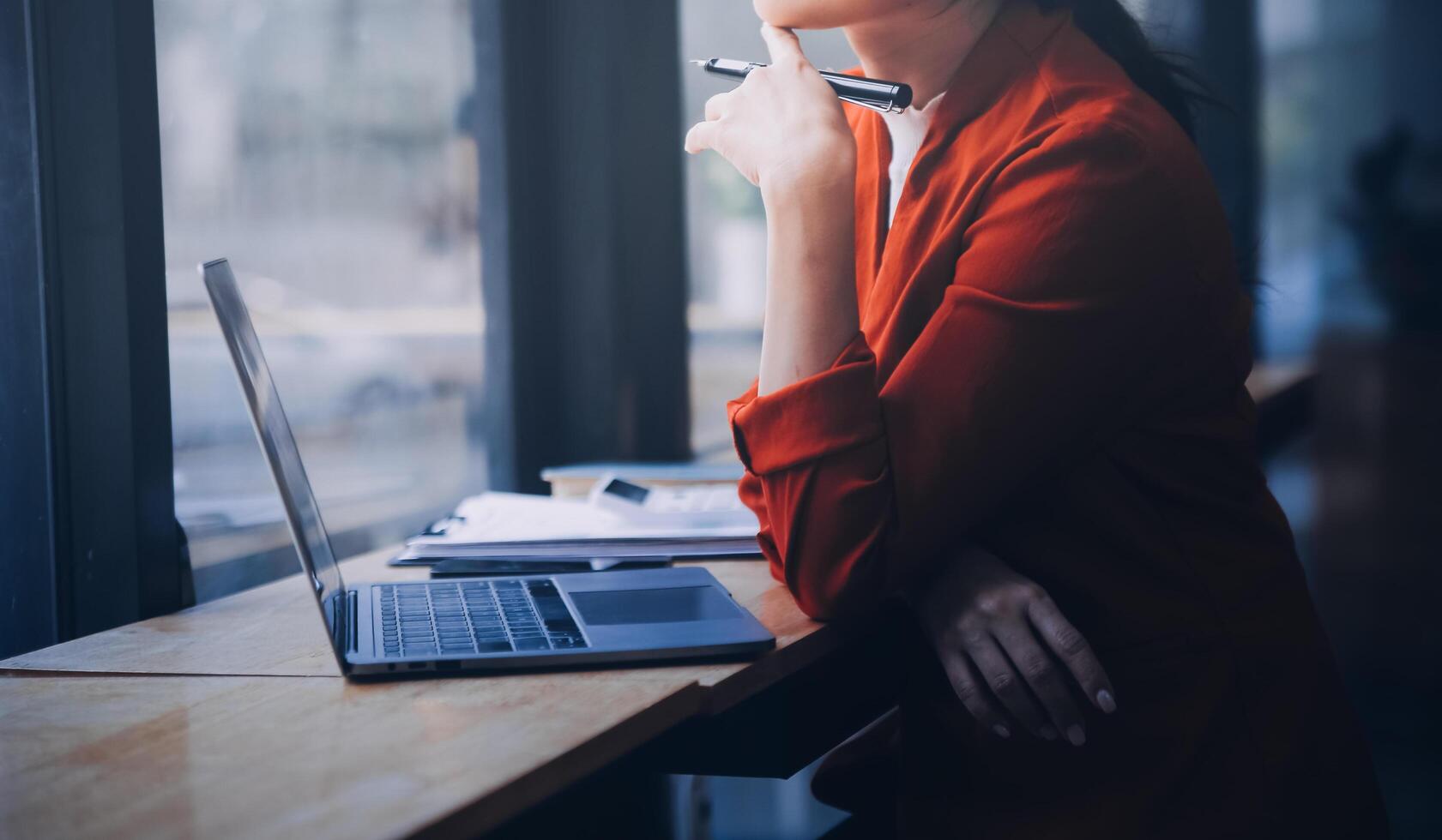 Asian Business woman using calculator and laptop for doing math finance on an office desk, tax, report, accounting, statistics, and analytical research concept photo