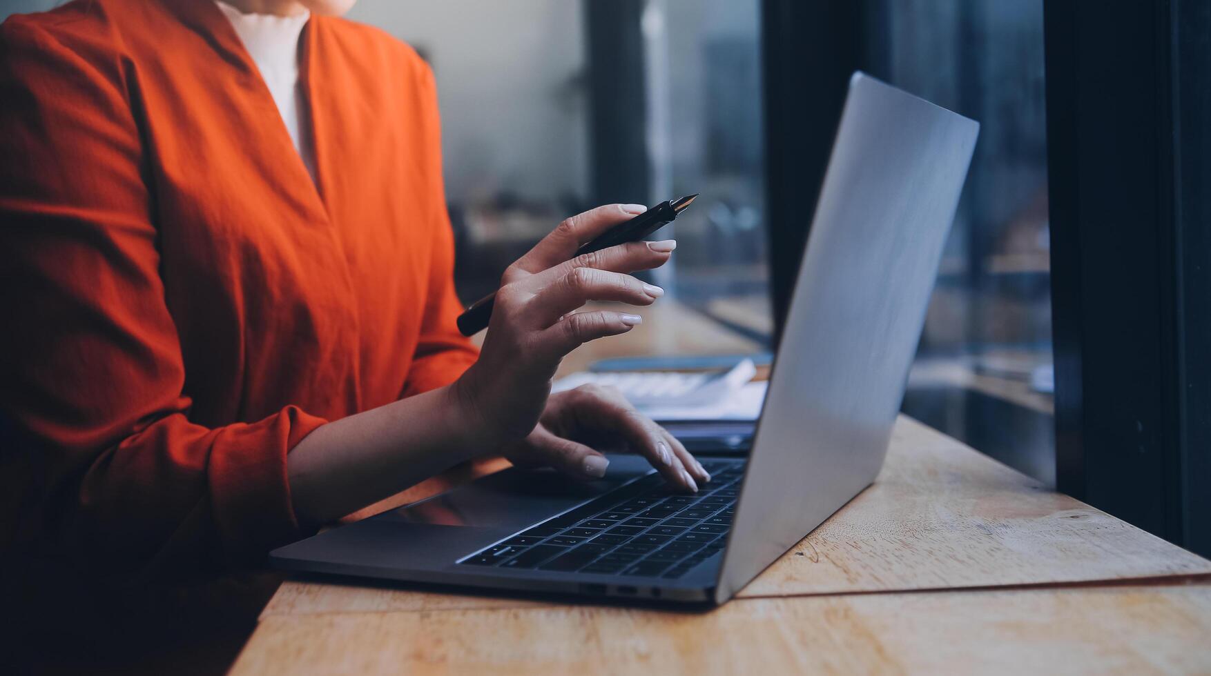 Asian Business woman using calculator and laptop for doing math finance on an office desk, tax, report, accounting, statistics, and analytical research concept photo