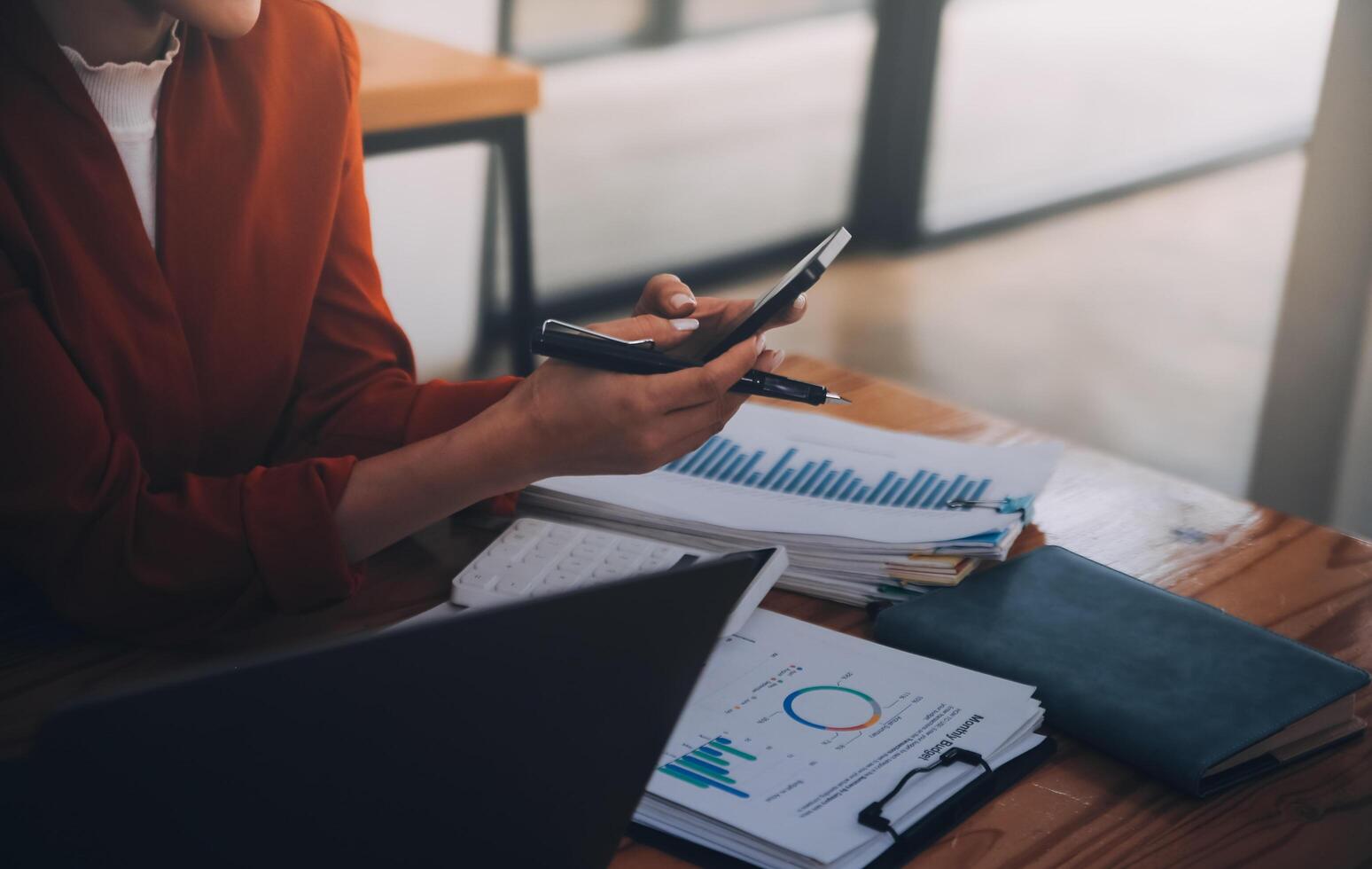 Asian Business woman using calculator and laptop for doing math finance on an office desk, tax, report, accounting, statistics, and analytical research concept photo