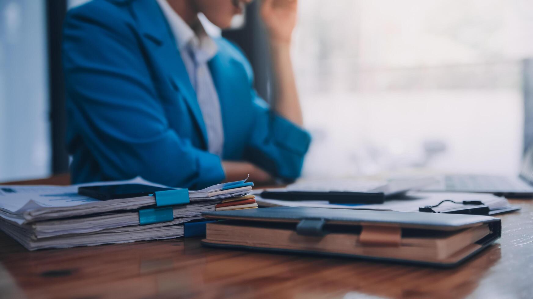 Asian Business woman using calculator and laptop for doing math finance on an office desk, tax, report, accounting, statistics, and analytical research concept photo