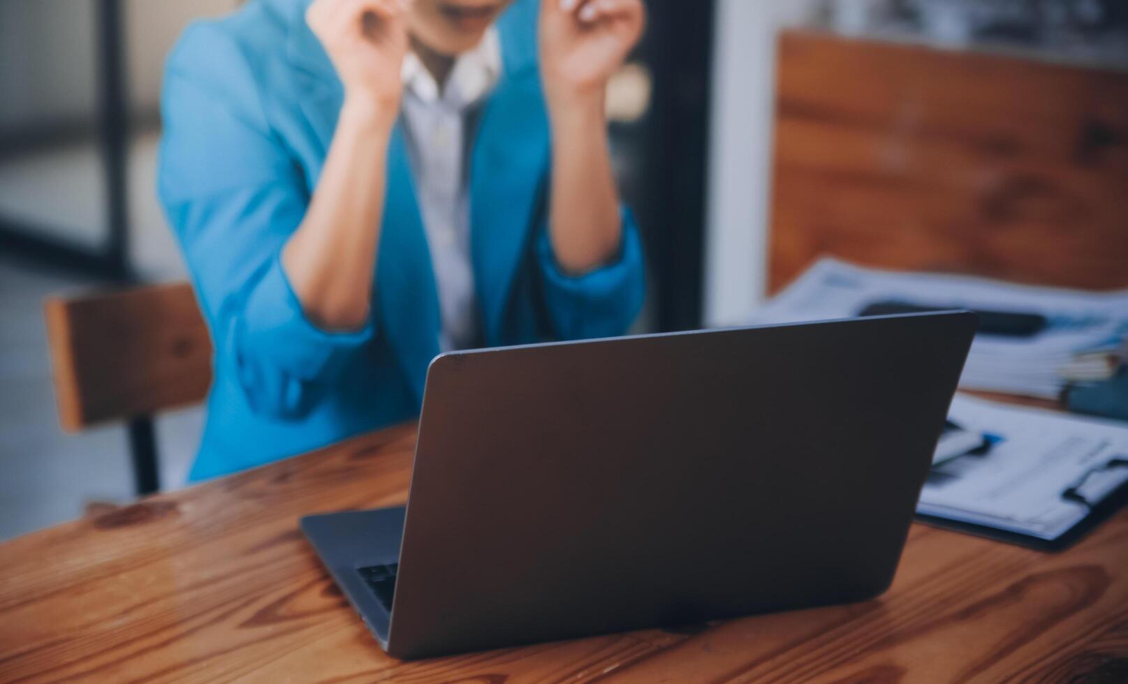 Asian Business woman using calculator and laptop for doing math finance on an office desk, tax, report, accounting, statistics, and analytical research concept photo