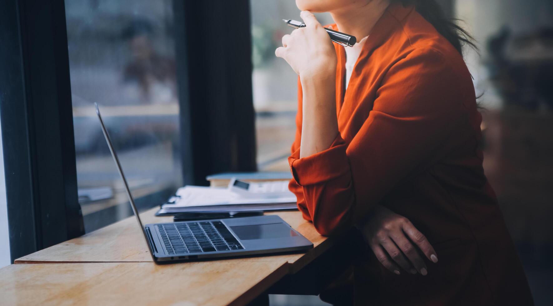 Asian Business woman using calculator and laptop for doing math finance on an office desk, tax, report, accounting, statistics, and analytical research concept photo