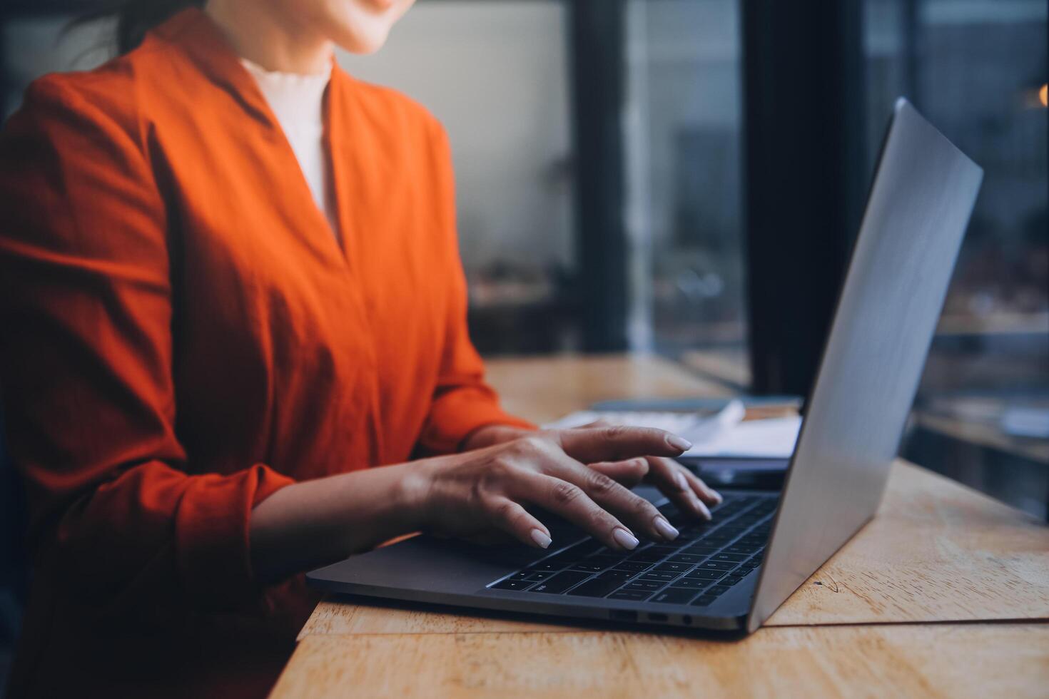 Asian Business woman using calculator and laptop for doing math finance on an office desk, tax, report, accounting, statistics, and analytical research concept photo