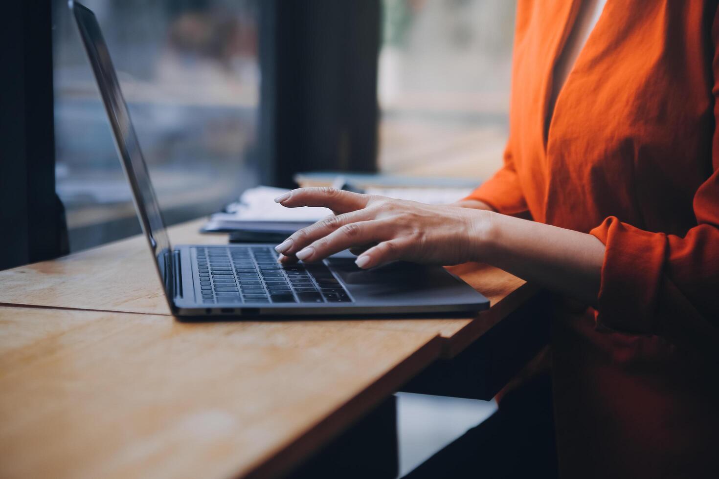 Asian Business woman using calculator and laptop for doing math finance on an office desk, tax, report, accounting, statistics, and analytical research concept photo
