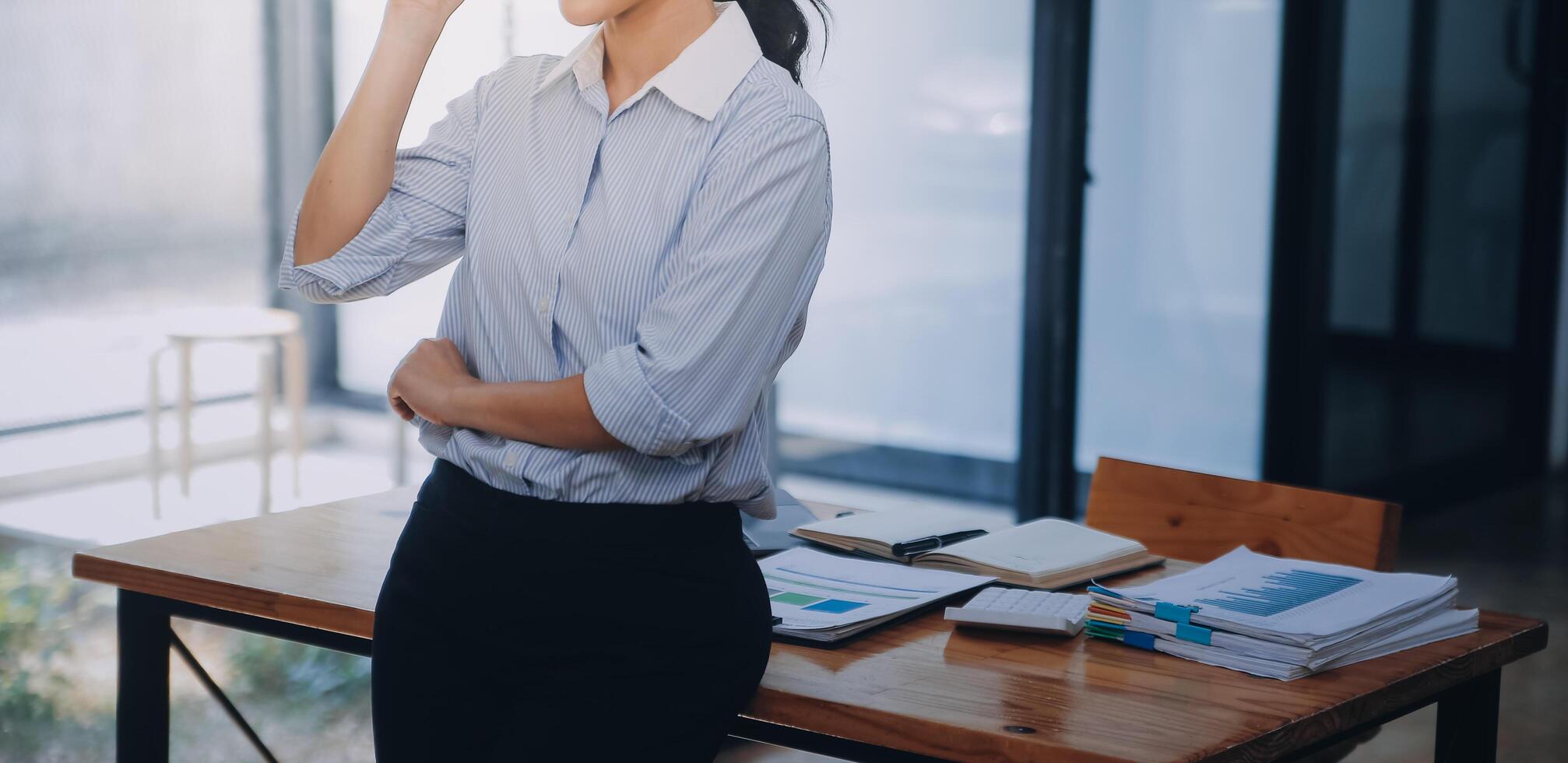 Asian Business woman using calculator and laptop for doing math finance on an office desk, tax, report, accounting, statistics, and analytical research concept photo