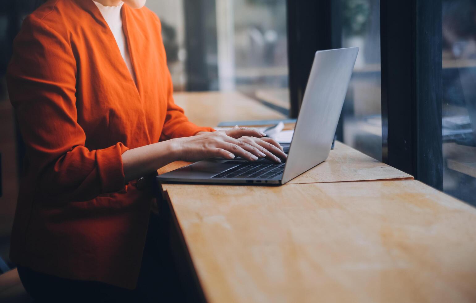 Asian Business woman using calculator and laptop for doing math finance on an office desk, tax, report, accounting, statistics, and analytical research concept photo
