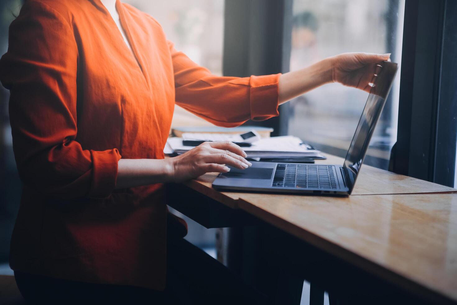 Asian Business woman using calculator and laptop for doing math finance on an office desk, tax, report, accounting, statistics, and analytical research concept photo