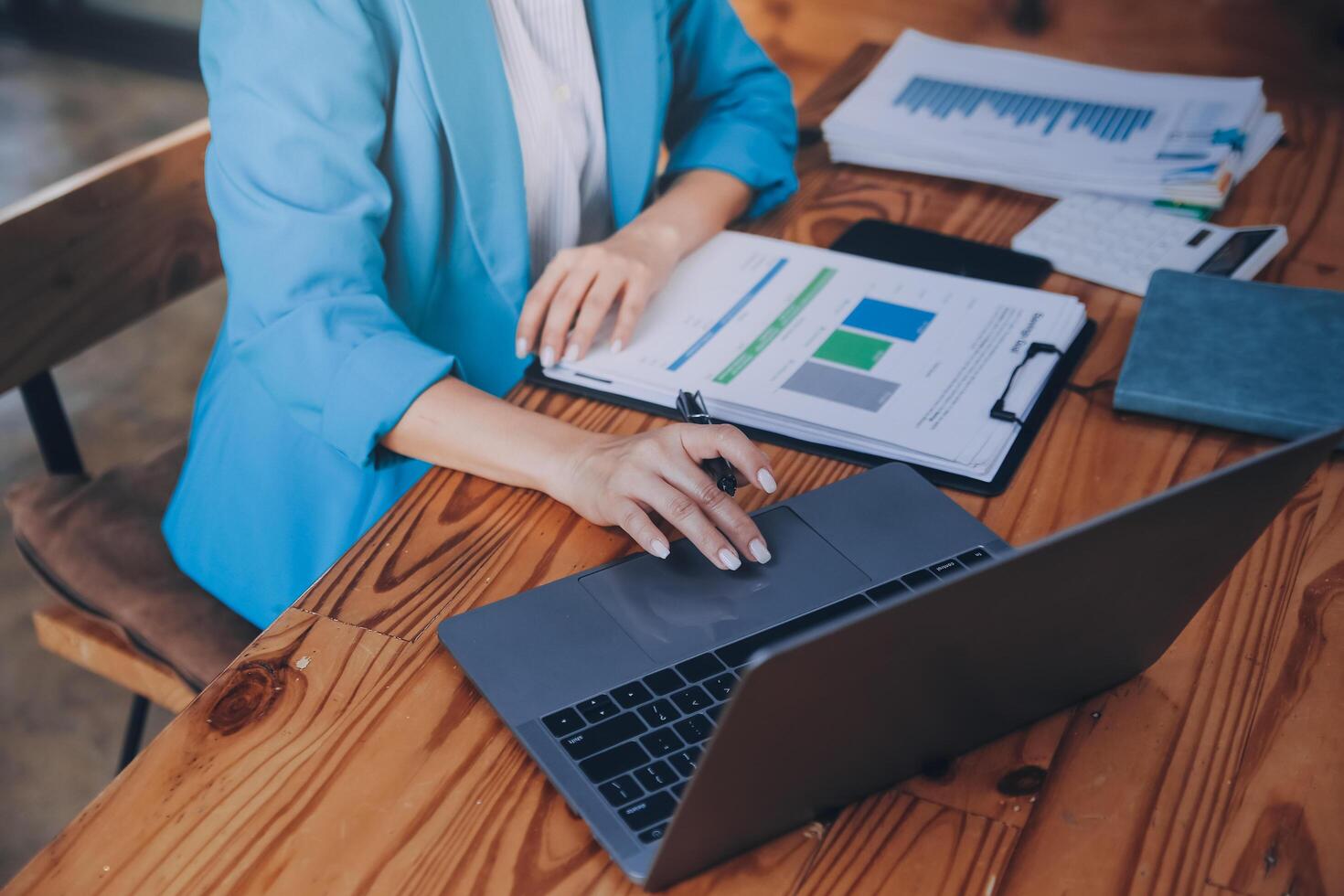 Asian Business woman using calculator and laptop for doing math finance on an office desk, tax, report, accounting, statistics, and analytical research concept photo
