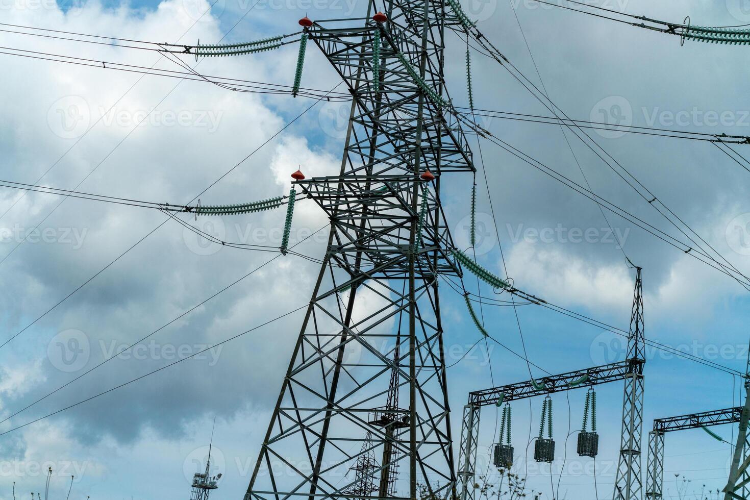 High voltage towers with sky background. Power line support with wires for electricity transmission. High voltage grid tower with wire cable at distribution station. Energy industry, energy saving photo
