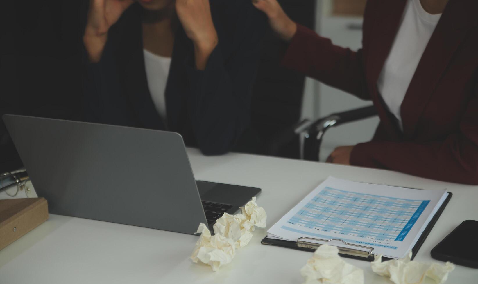 Stressed annoyed office employee manager having headache migraine at business meeting with his colleagues about business problem they have to solve. Stress at work or migraine concept. photo