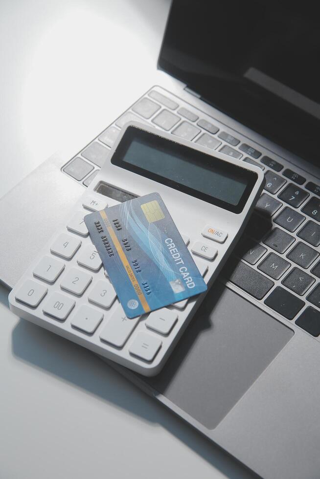 Calculator on a dark background, plastic cards and banknotes photo