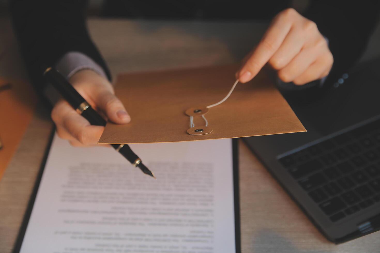 Business and lawyers discussing contract papers with brass scale on desk in office. Law, legal services, advice, justice and law concept picture with film grain effect photo