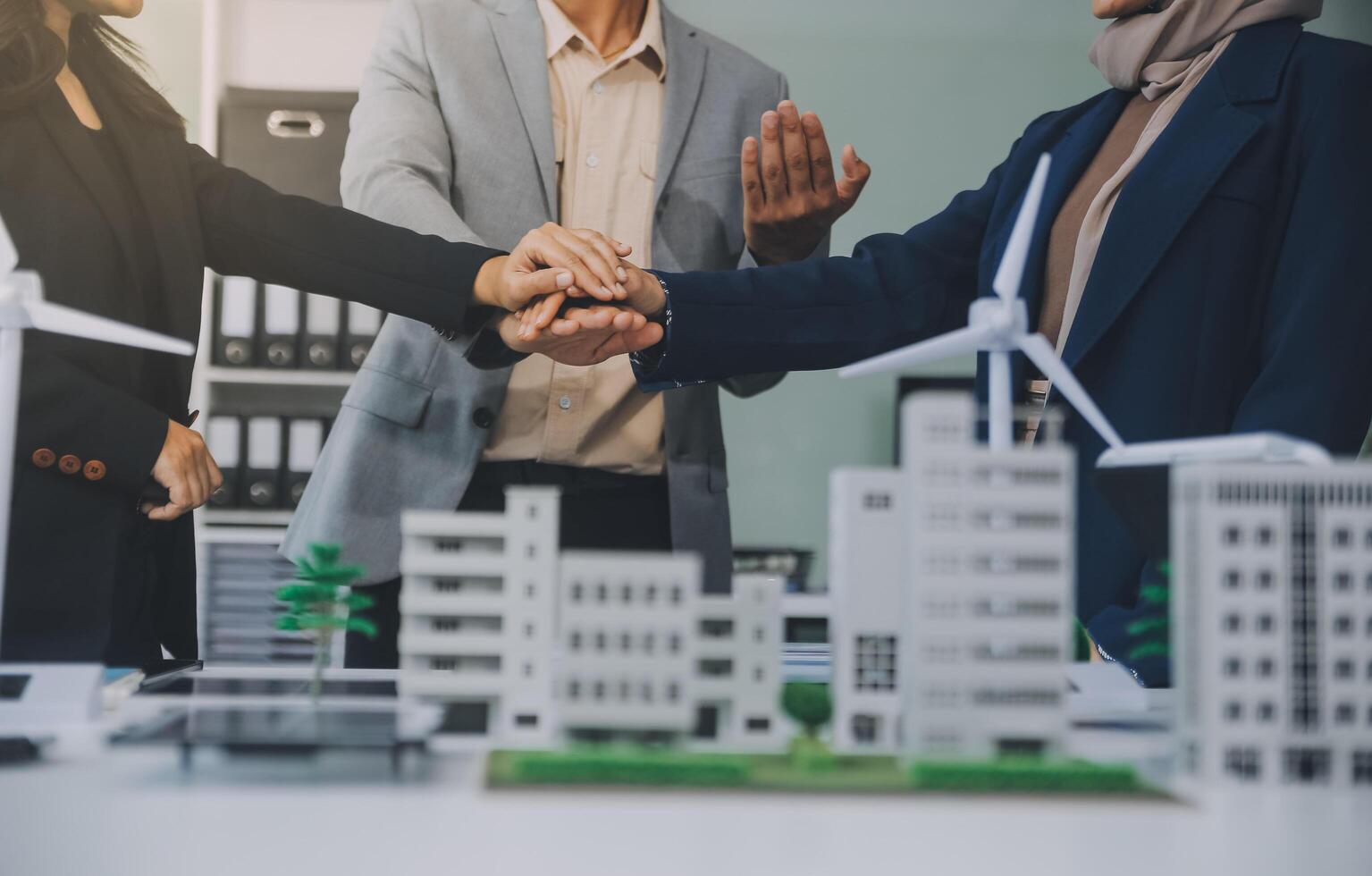 Two business executives, elegantly attired in suits, join hands in a gesture of unity, solidarity, and shared commitment towards a common goal or venture. photo
