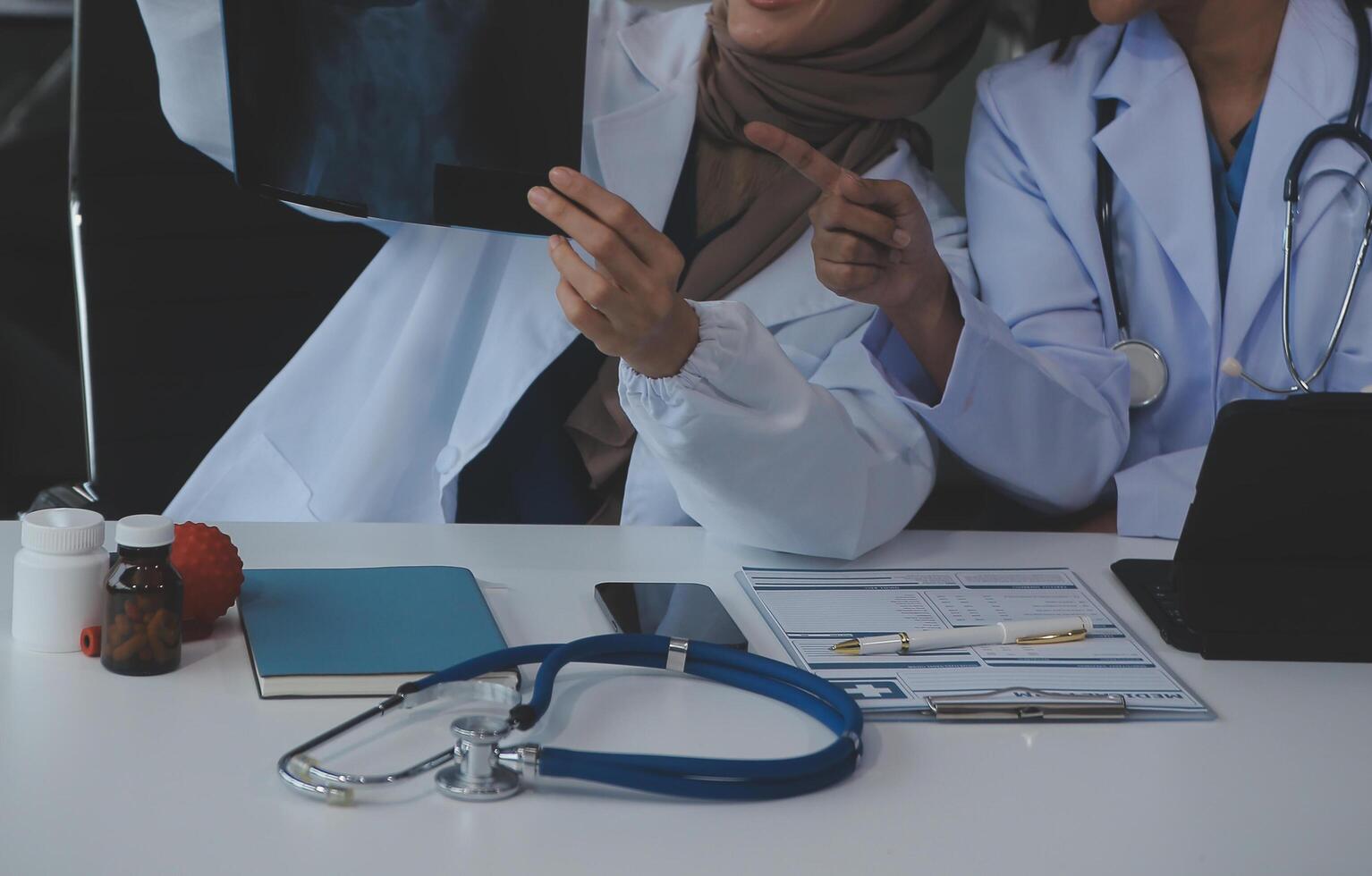Doctor discussing diagnosis during the meeting. Group of doctor discussing work matter in the office at work. The medical team discusses treatment options with the patient. photo