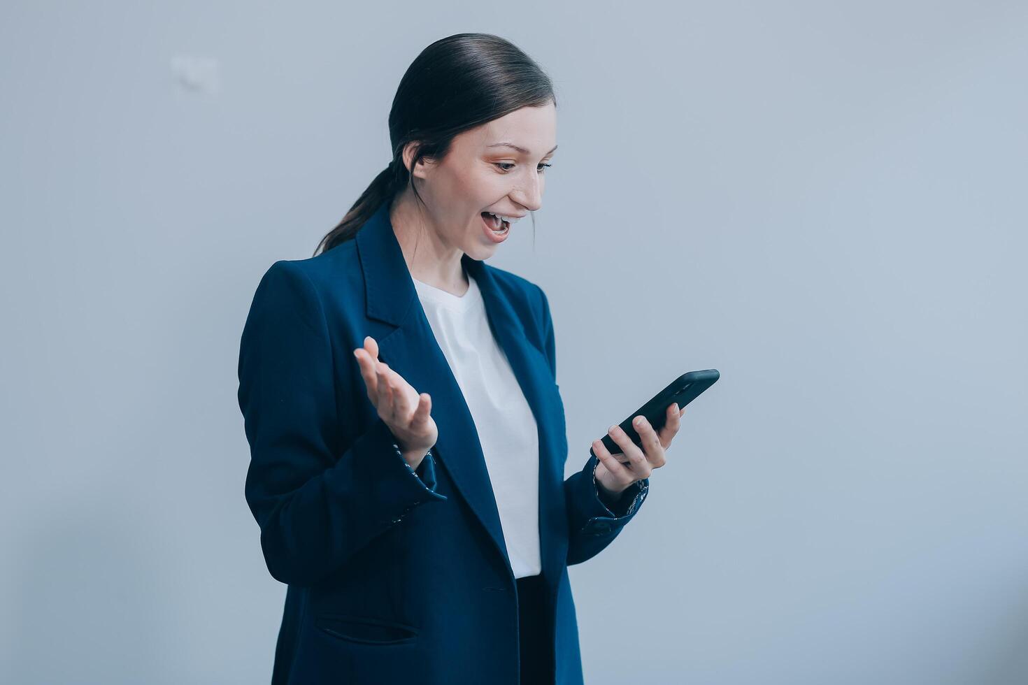 Portrait of a happy asian businesswoman using mobile phone isolated over white background photo