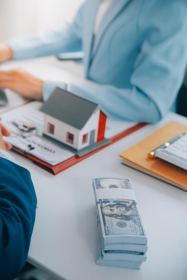 Real estate agent talked about the terms of the home purchase agreement and asked the customer to sign the documents to make the contract legally, Home sales and home insurance concept. photo