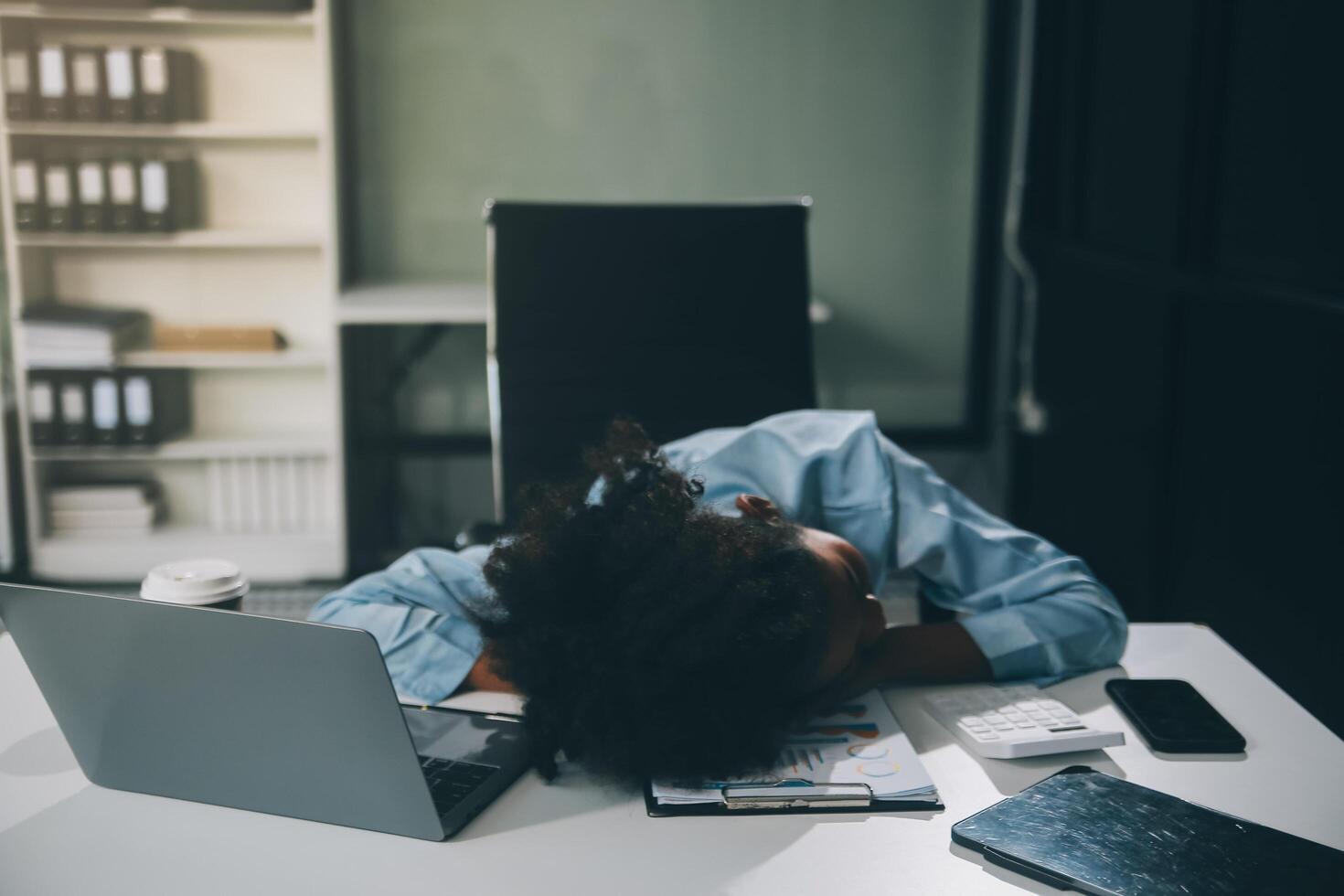 Sad tired young asian lady thinking, sleep at laptop, suffering from overwork, stress in room interior. Deadline, problems in study, work, business, freelance at home new normal with tech photo