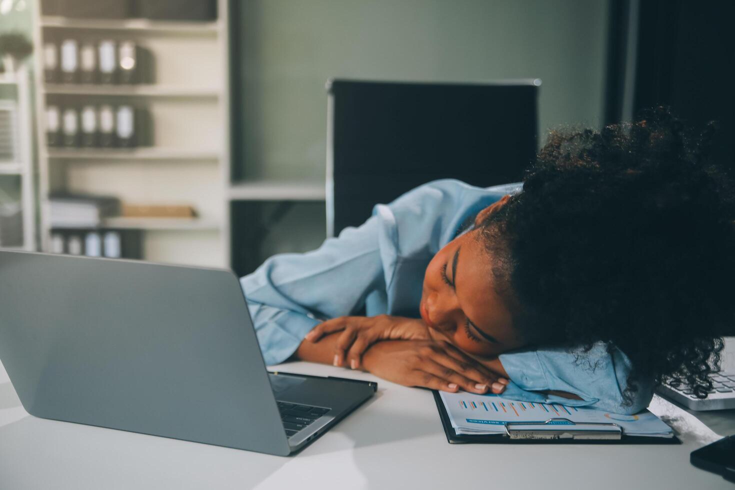 Sad tired young asian lady thinking, sleep at laptop, suffering from overwork, stress in room interior. Deadline, problems in study, work, business, freelance at home new normal with tech photo