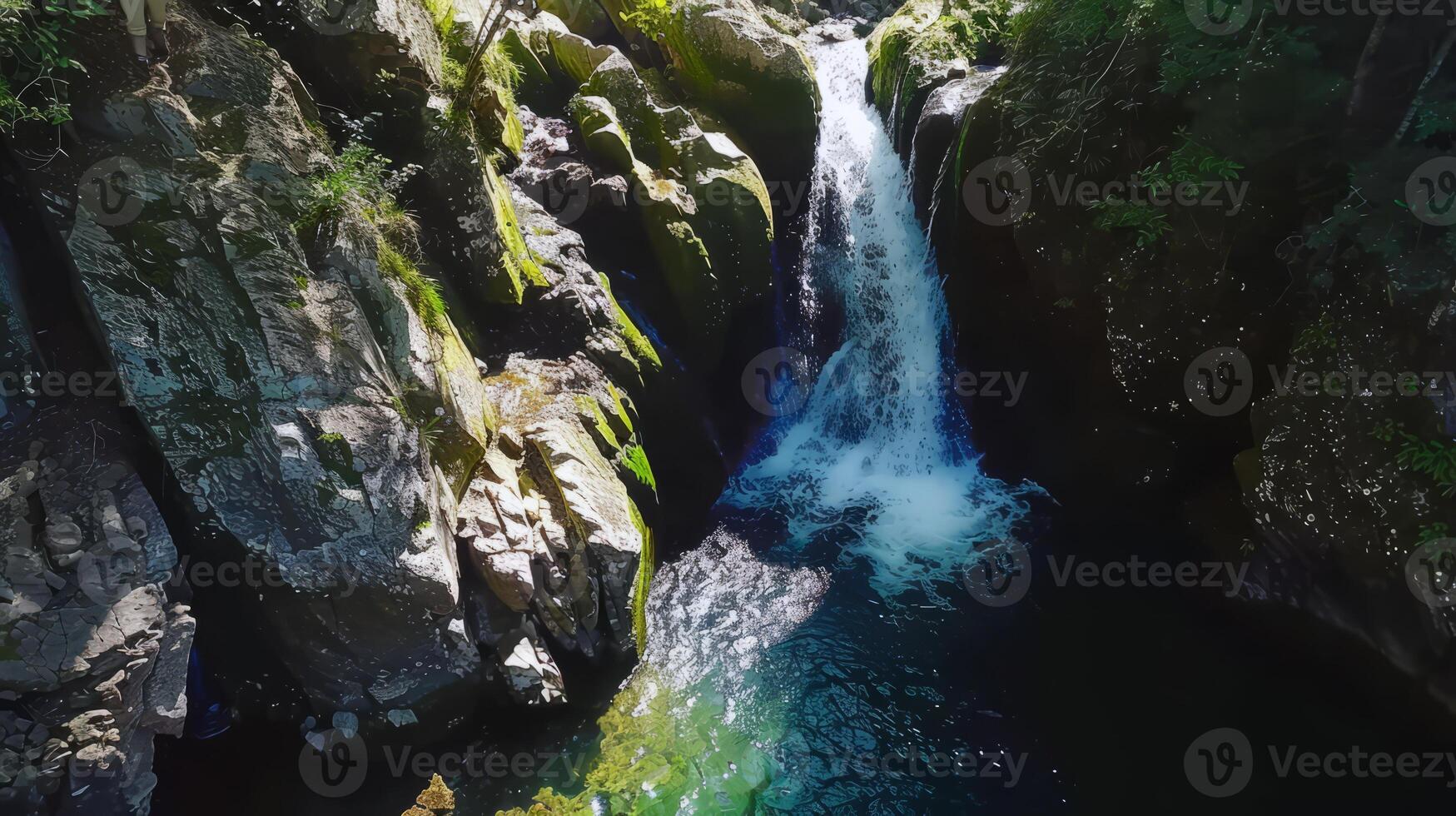 Majestic waterfall cascading down moss-covered rocks into refreshing pool below photo