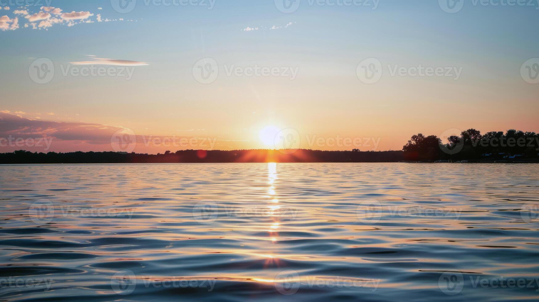 Sunset over tranquil lake, casting warm glow over the water and surrounding landscape photo