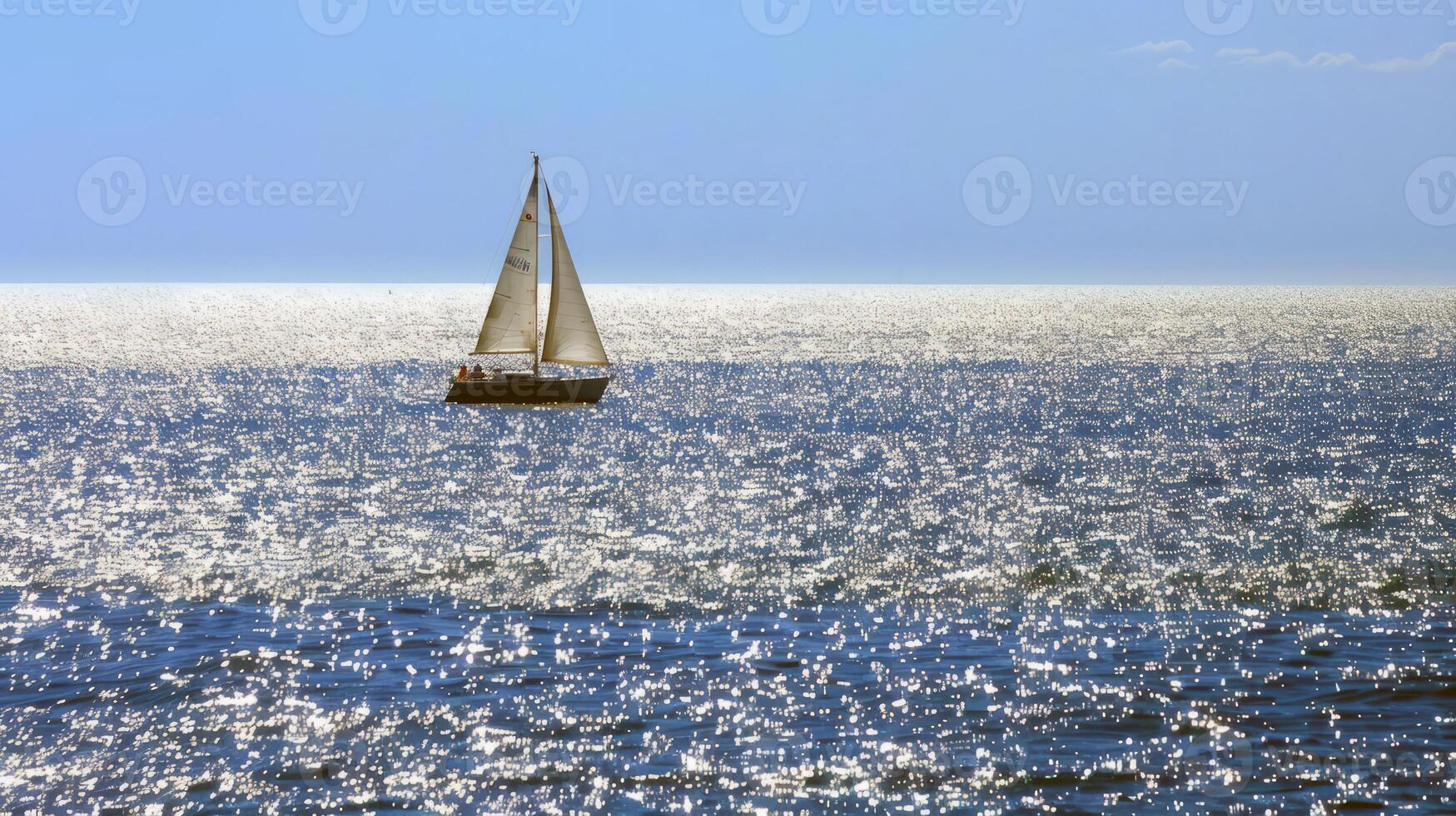 Sailboat gliding across sparkling blue waters, propelled by gentle summer breeze photo