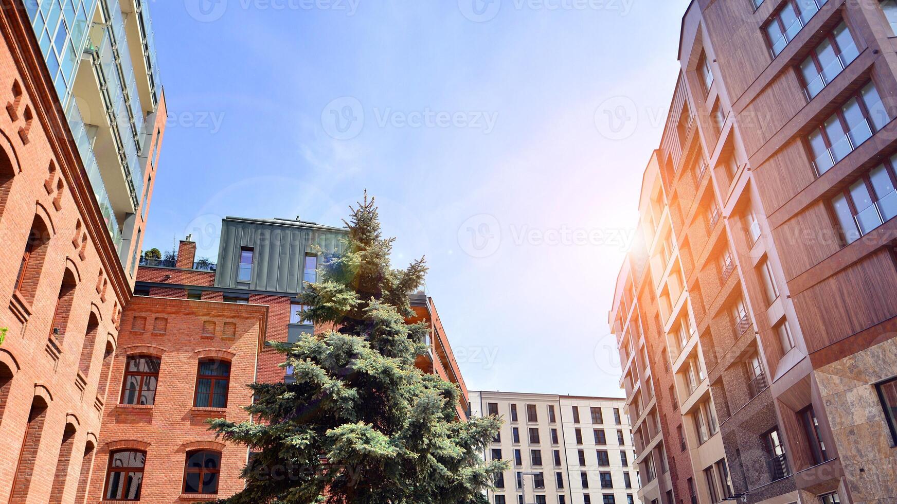 Modern residential building with new apartments in a green residential area. Eco architecture. Green tree and new apartment building. The harmony of nature and modernity. photo
