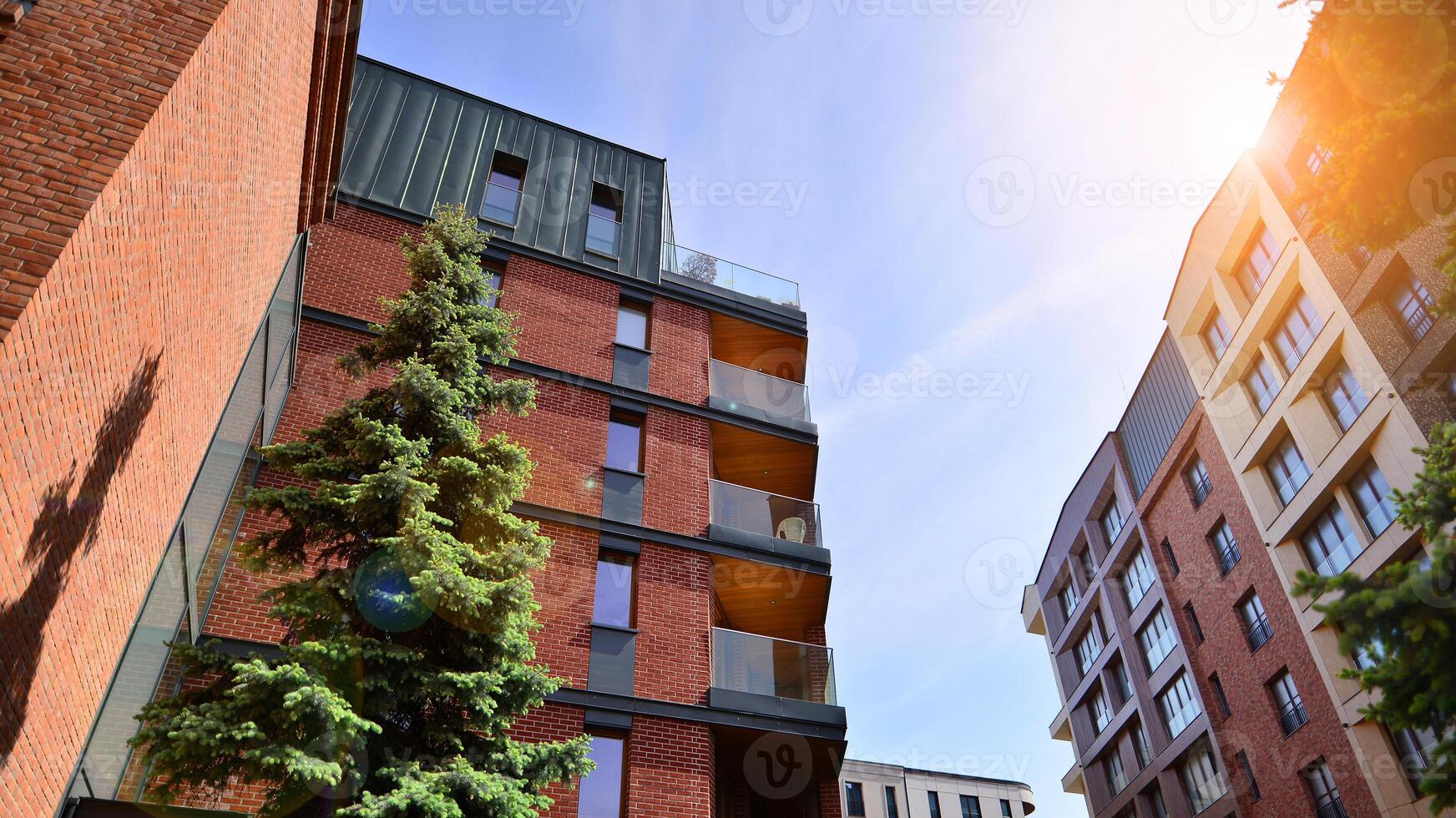 Modern residential building with new apartments in a green residential area. Eco architecture. Green tree and new apartment building. The harmony of nature and modernity. photo