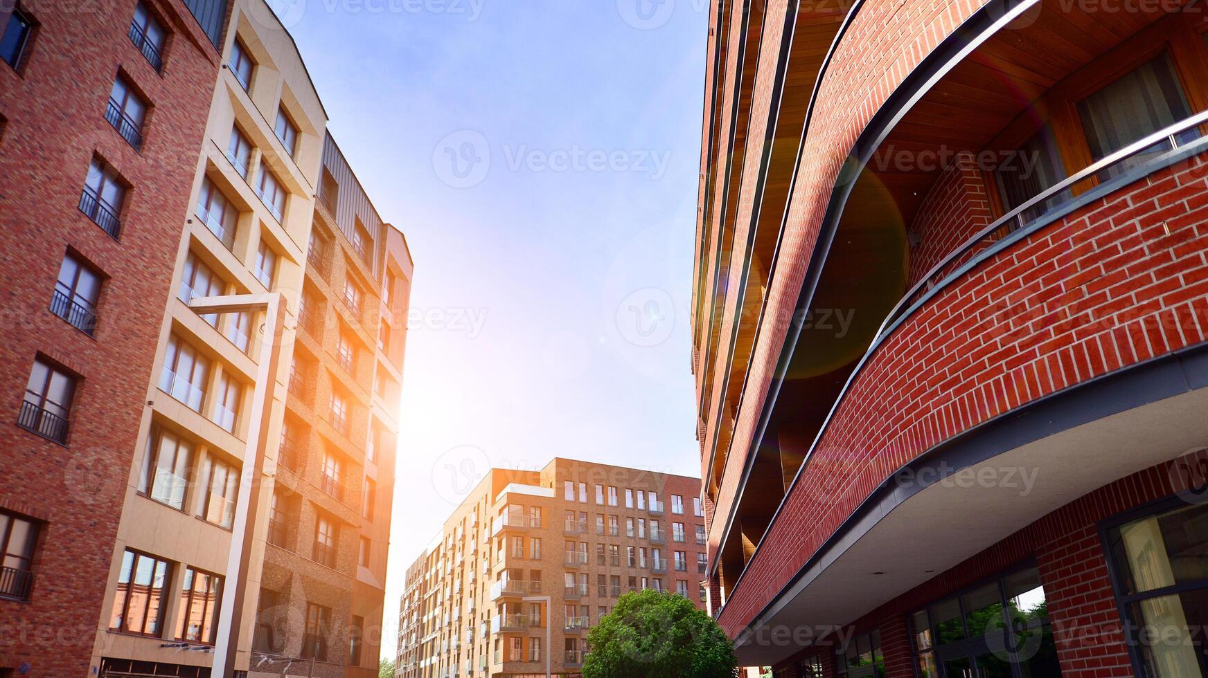 Modern residential building with new apartments in a green residential area. Eco architecture. Green tree and new apartment building. The harmony of nature and modernity. photo
