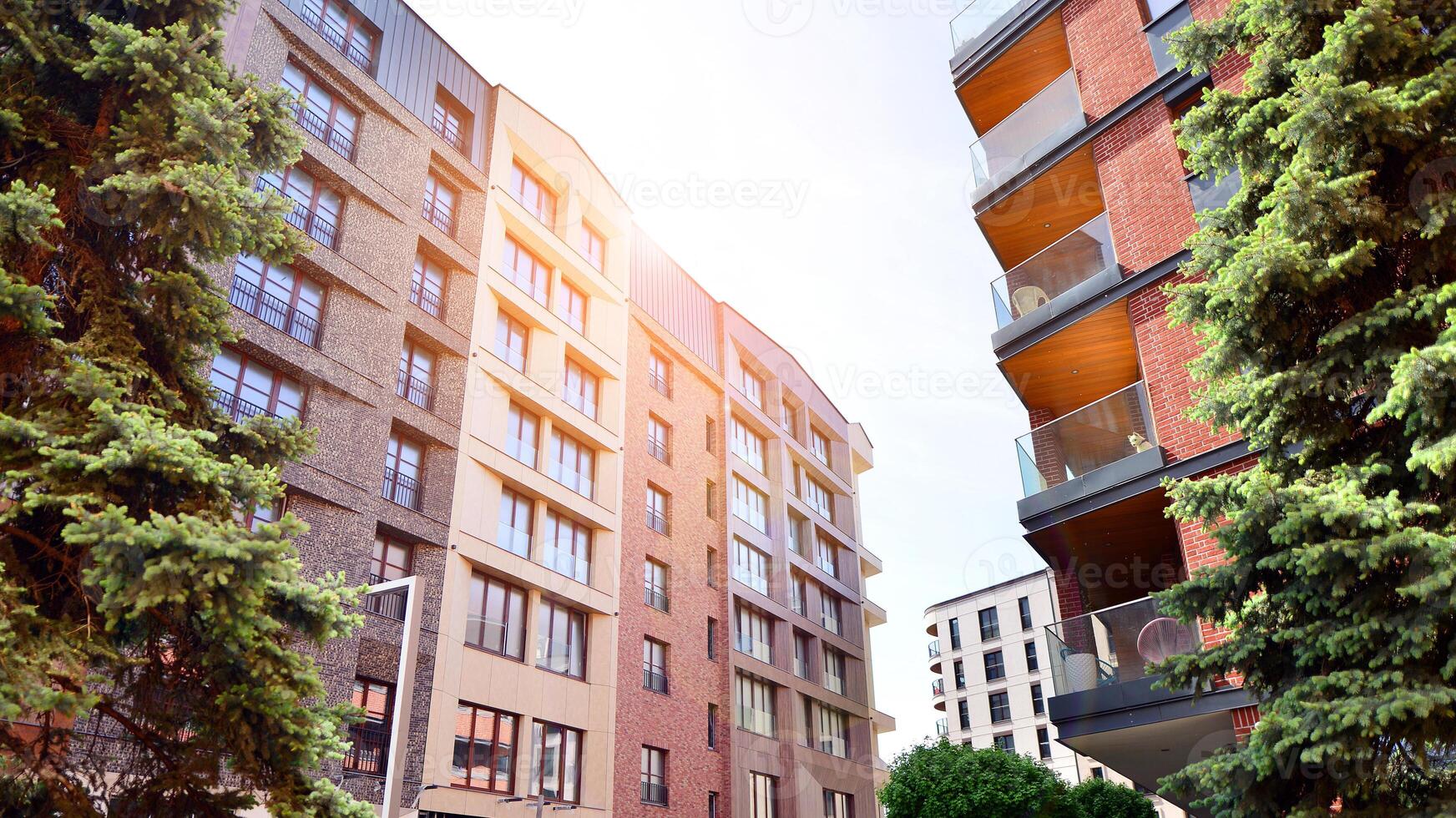 Modern residential building with new apartments in a green residential area. Eco architecture. Green tree and new apartment building. The harmony of nature and modernity. photo