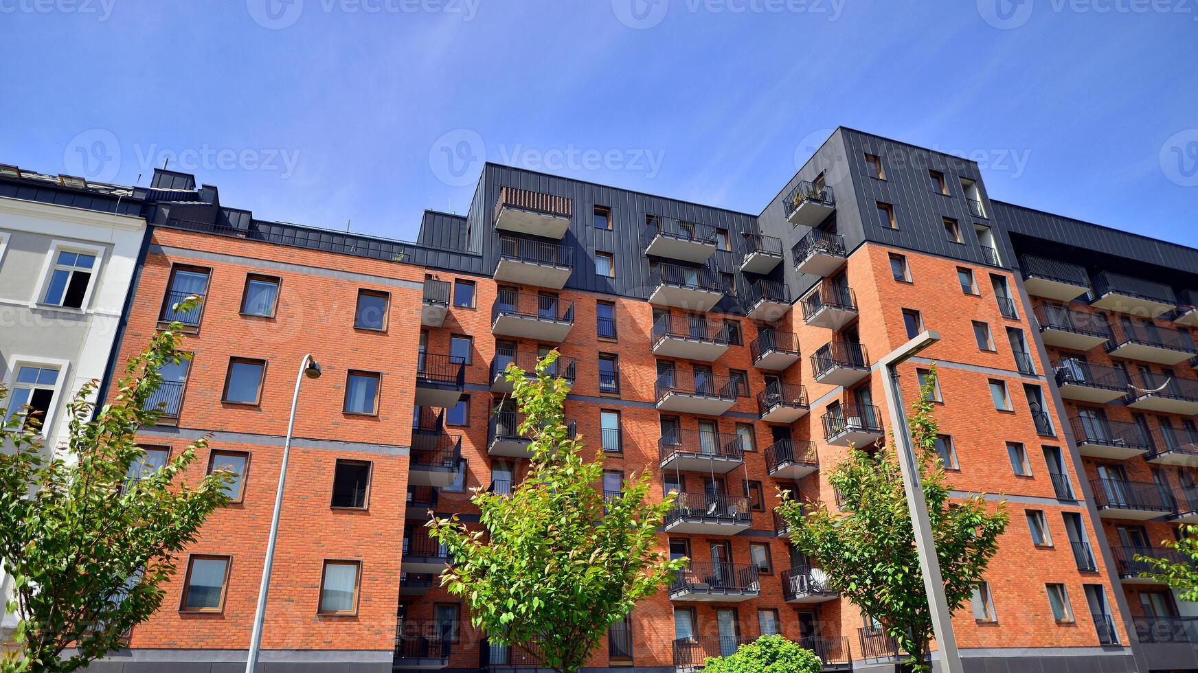 Modern residential building with new apartments in a green residential area. Eco architecture. Green tree and new apartment building. The harmony of nature and modernity. photo