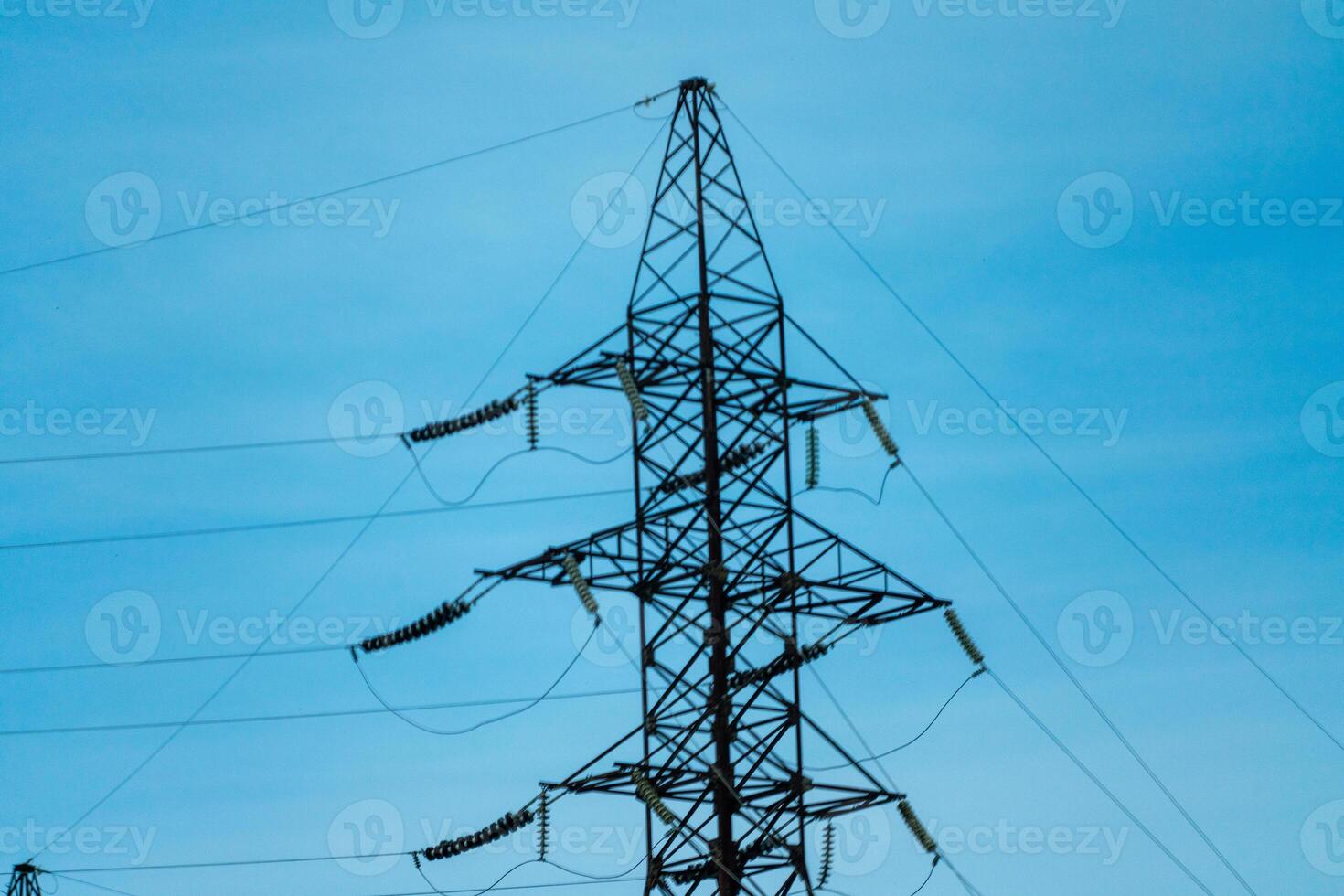 High voltage towers with sky background. Power line support with wires for electricity transmission. High voltage grid tower with wire cable at distribution station. Energy industry, energy saving photo