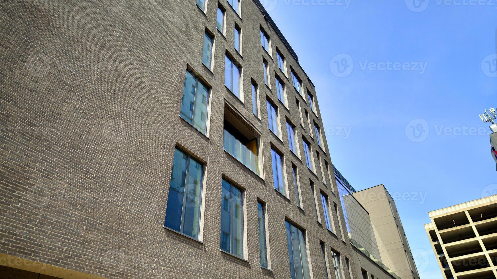 Modern office building detail. Perspective view of geometric angular concrete windows on the facade of a modernist brutalist style building. photo