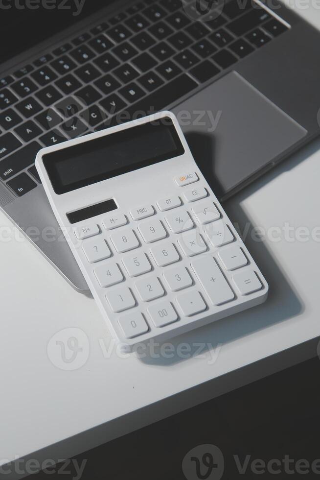 Flat lay, top view office table desk. Workspace with calculator,pen,laptop on white background.Copy Space for text,Empty Blank to word.Business Finance,Education Technology.Work from home. photo