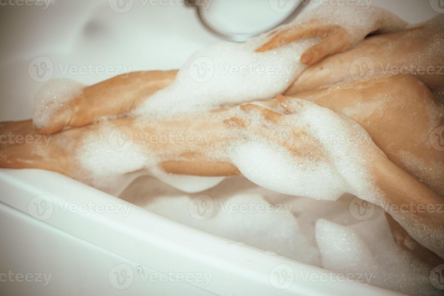 Women's feet in bath foam. View from above. Enjoy and relax in a spa hotel photo