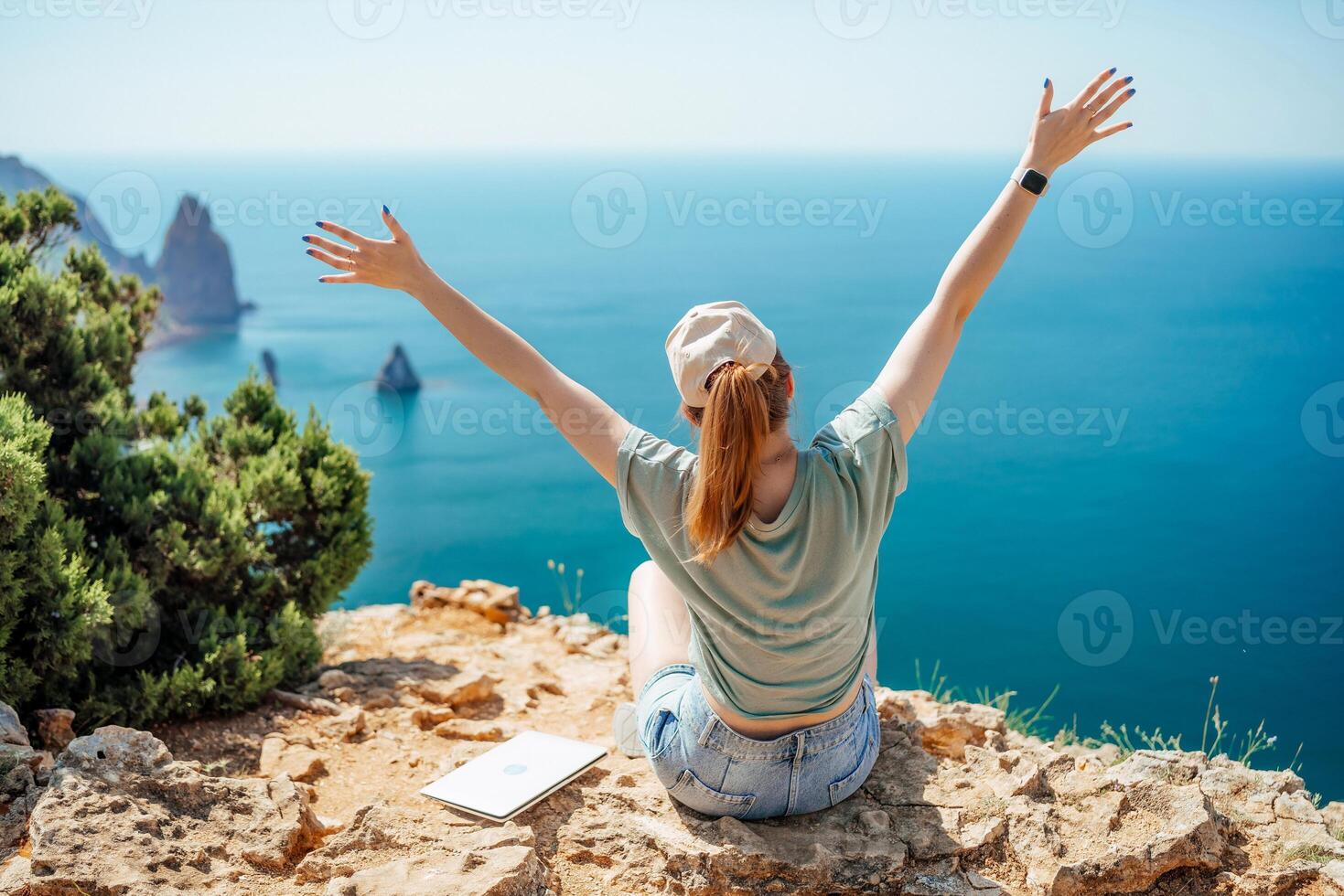 Woman tourist sky sea. Happy traveller woman in hat enjoys vacation raised her hands up photo