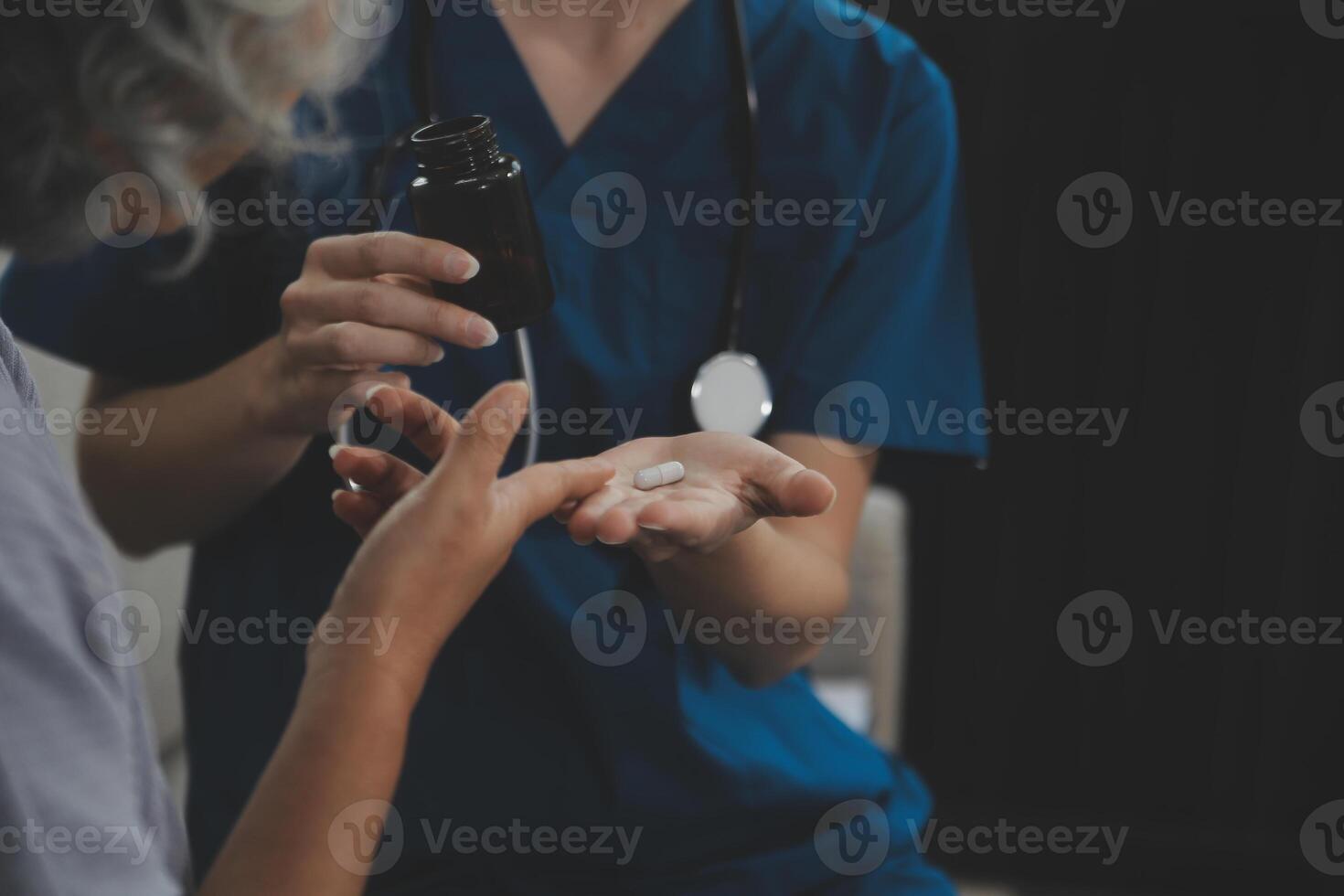Female caregiver doing regular check-up of senior woman in her home. photo