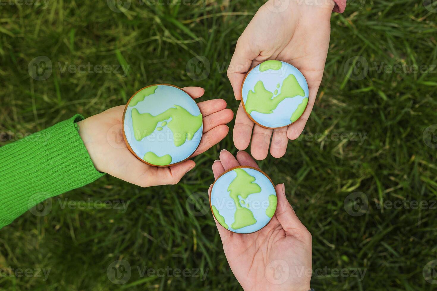 Earth Day concept. Hands hold gingerbread in the shape of the Earth. Care for the environment. photo