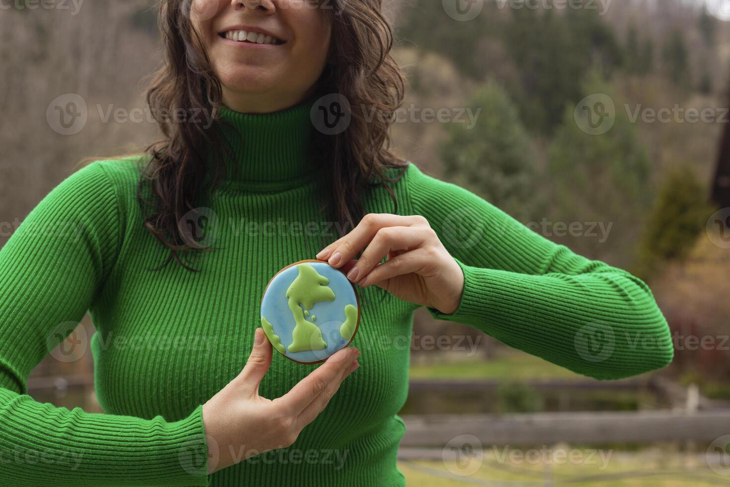 Earth Day concept. Gingerbread in the shape of a planet in the hands of a woman. photo