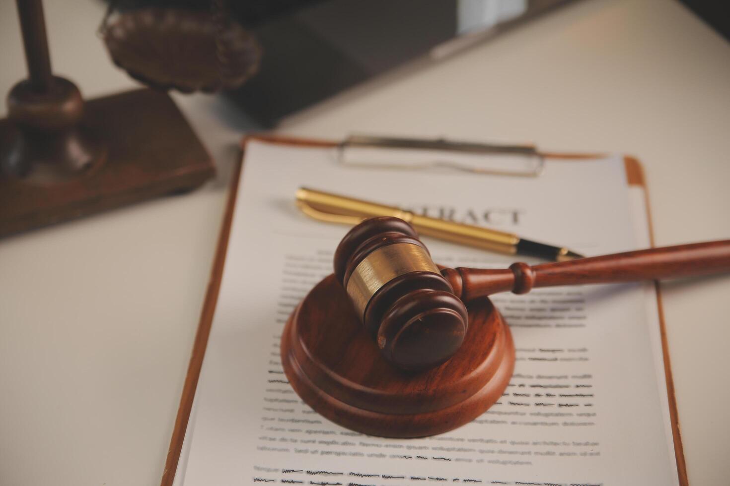 image of judge's hammer, scales lady of justice, law book, laptop computer and contract documents with pen concept of law and justice. photo