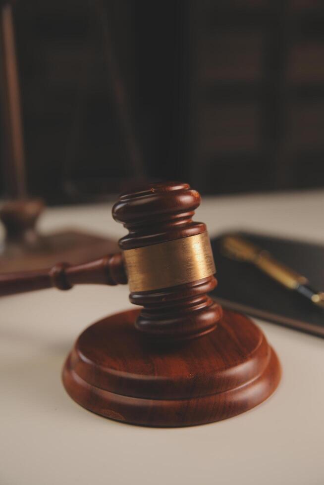 image of judge's hammer, scales lady of justice, law book, laptop computer and contract documents with pen concept of law and justice. photo