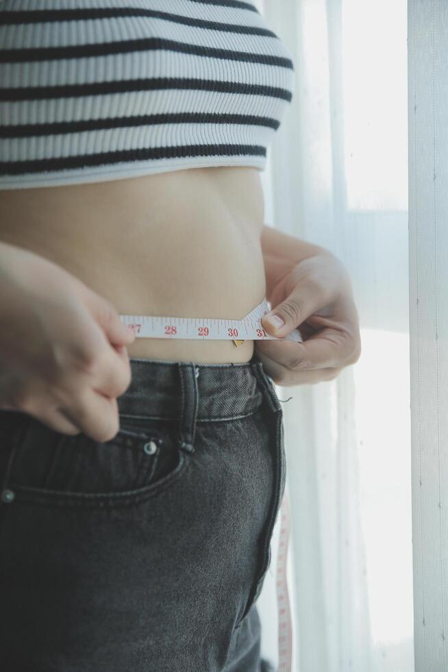 Women body fat belly. Obese woman hand holding excessive belly fat. diet lifestyle concept to reduce belly and shape up healthy stomach muscle. photo
