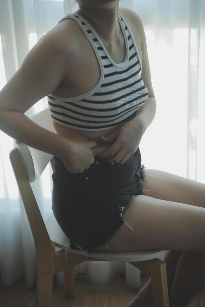 Women body fat belly. Obese woman hand holding excessive belly fat. diet lifestyle concept to reduce belly and shape up healthy stomach muscle. photo
