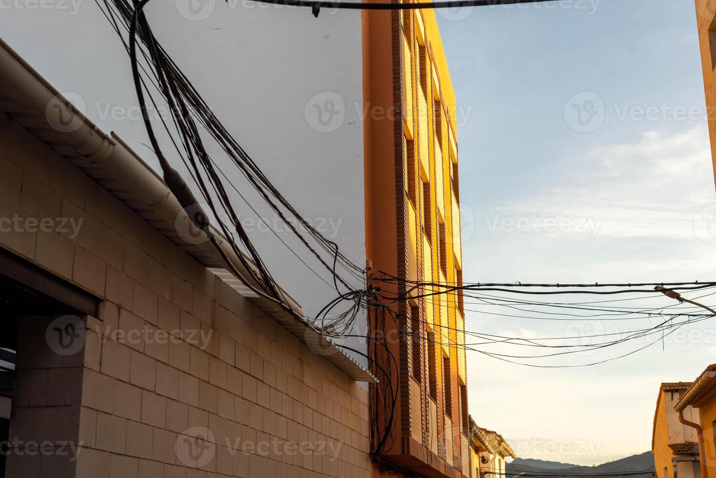 exterior de un edificio con muchos eléctrico alambres corriendo a través de el calle fuera de foto