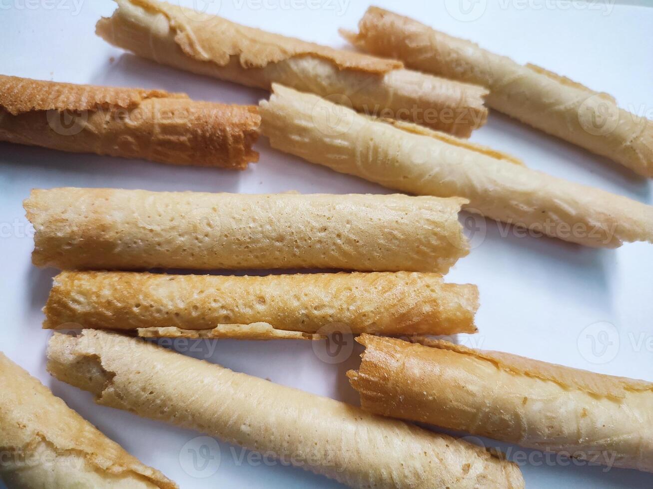 Kue semprong or Asian egg roll. This is a traditional Indonesian wafer or kuih snack isolated on a white background photo