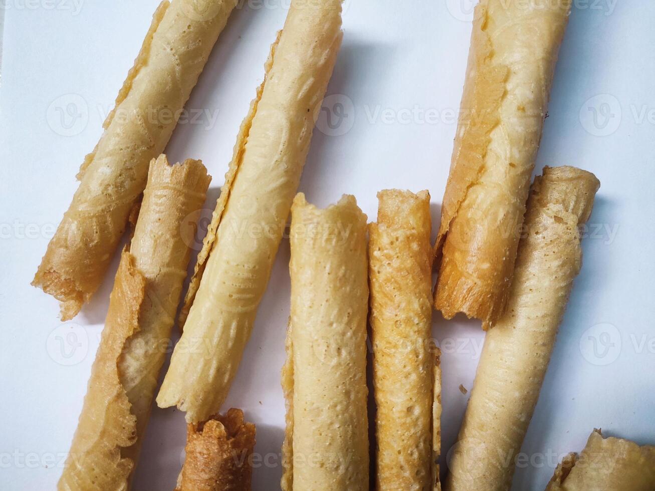 Kue semprong or Asian egg roll. This is a traditional Indonesian wafer or kuih snack isolated on a white background photo